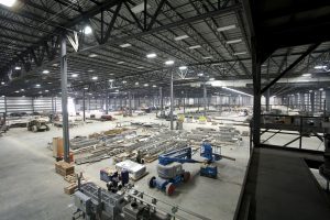 inside construction of large metal building with supplies and a lift