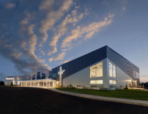 Dramatic exterior of LifePoint Church at dusk with backlit cross