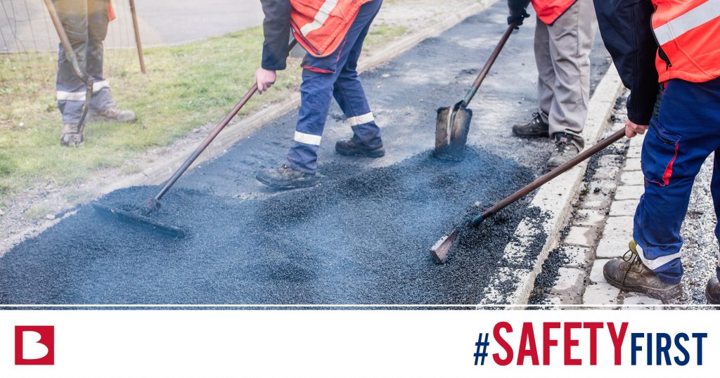 workers leveling out asphalt with the hashtag #safetyfirst