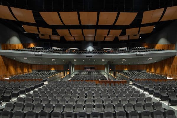 large auditorium seating with wood sound board hanging in the ceiling